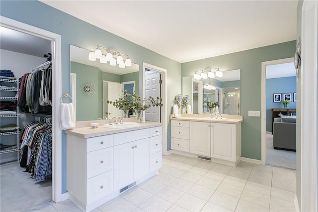 bathroom featuring two vanities, a stall shower, and a sink