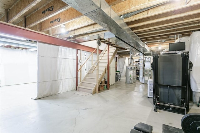 unfinished basement with stairway and water heater