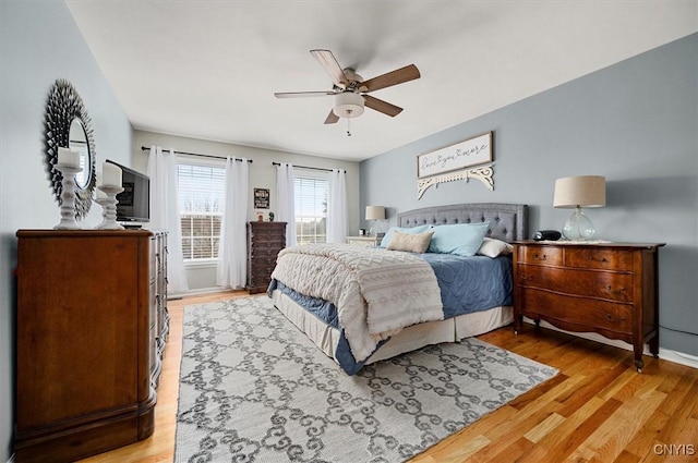 bedroom featuring a ceiling fan, baseboards, and light wood finished floors