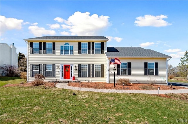 colonial-style house featuring a front lawn