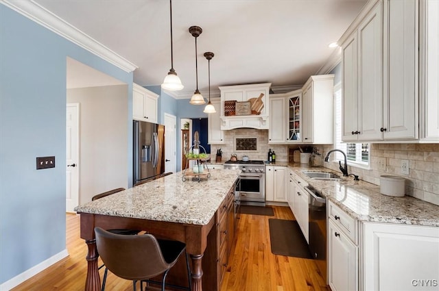 kitchen featuring a center island, backsplash, stainless steel appliances, and a sink