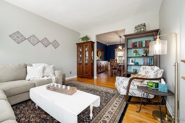 living room with wood finished floors, baseboards, and a chandelier