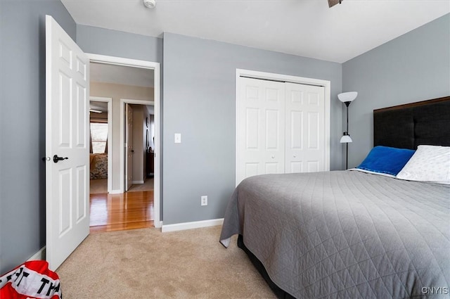 bedroom with baseboards, light carpet, and a closet