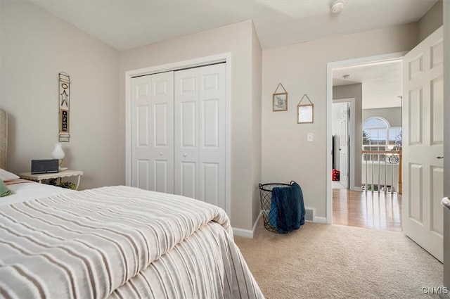 bedroom with visible vents, carpet, baseboards, and a closet