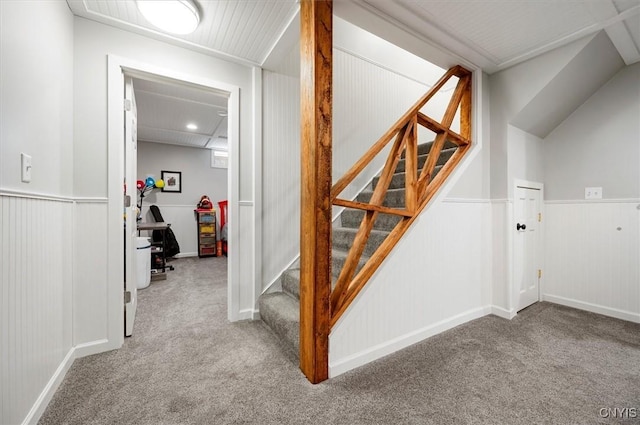 stairway featuring a wainscoted wall and carpet flooring