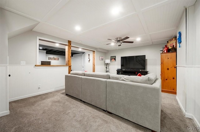 carpeted living room with a wainscoted wall and a ceiling fan