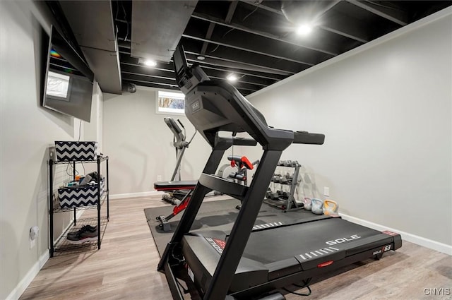 workout room featuring baseboards and wood finished floors