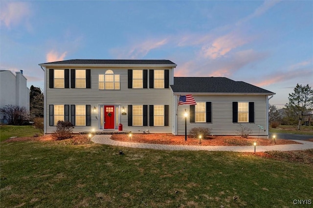 colonial inspired home with a front lawn