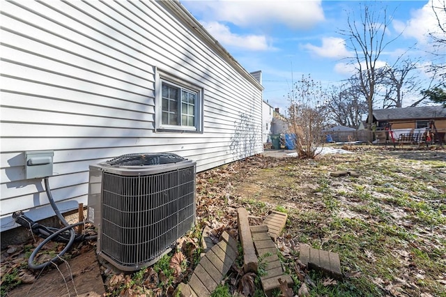 exterior details featuring central AC unit and fence