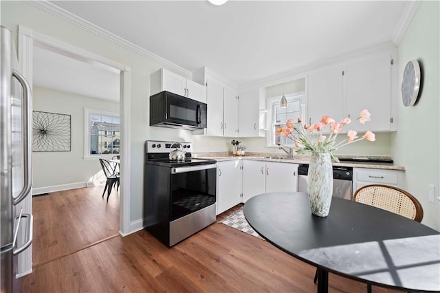 kitchen featuring ornamental molding, a sink, white cabinetry, stainless steel appliances, and dark wood-style flooring