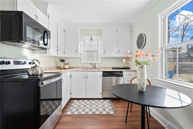 kitchen featuring a sink, appliances with stainless steel finishes, white cabinets, and light countertops