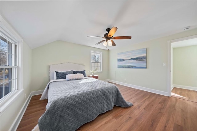 bedroom featuring a ceiling fan, vaulted ceiling, wood finished floors, and baseboards