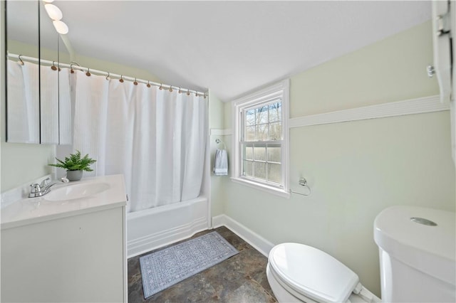 bathroom with toilet, shower / tub combo with curtain, stone finish floor, baseboards, and vanity