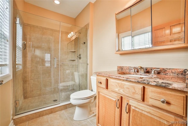 bathroom with tile patterned floors, vanity, toilet, and a shower stall