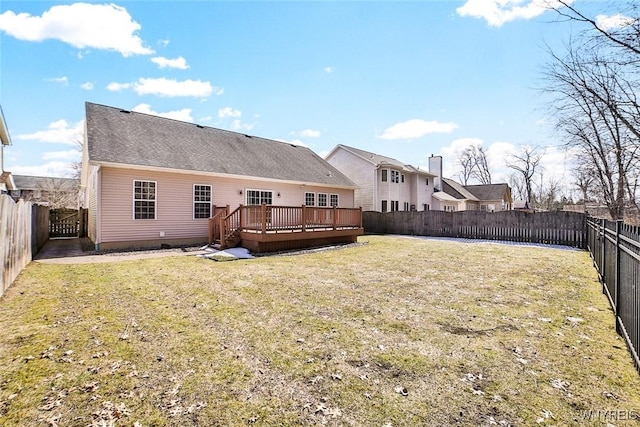 back of property with a wooden deck, a lawn, and a fenced backyard