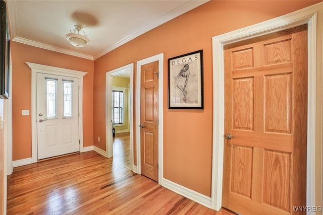 entrance foyer featuring baseboards, light wood-style floors, and ornamental molding