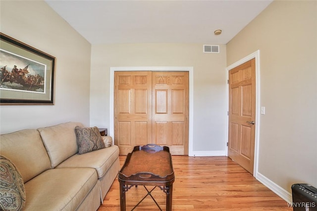 living area with visible vents, baseboards, and light wood-style floors