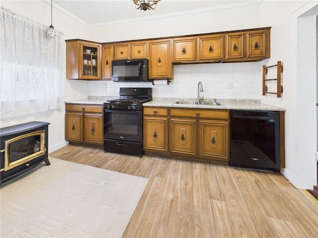 kitchen featuring black appliances, brown cabinetry, and a sink