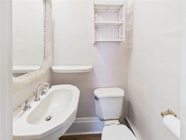 half bathroom featuring a sink, baseboards, and toilet