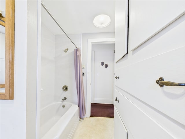 bathroom featuring baseboards and shower / tub combo with curtain