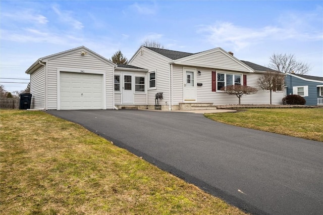 ranch-style house with entry steps, a front lawn, a garage, and driveway