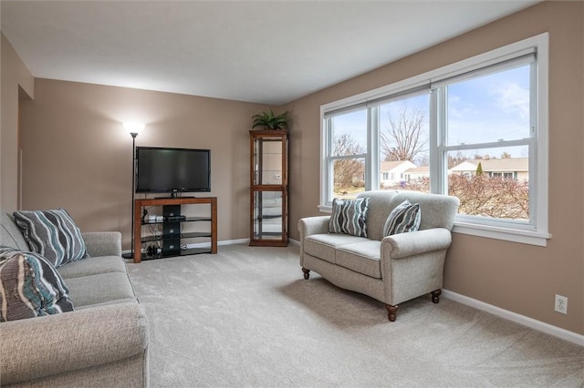 carpeted living area with baseboards