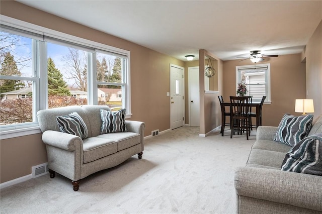 living room featuring visible vents, light colored carpet, and a healthy amount of sunlight