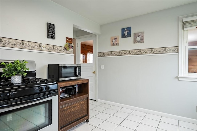 kitchen featuring light tile patterned flooring, baseboards, and stainless steel appliances