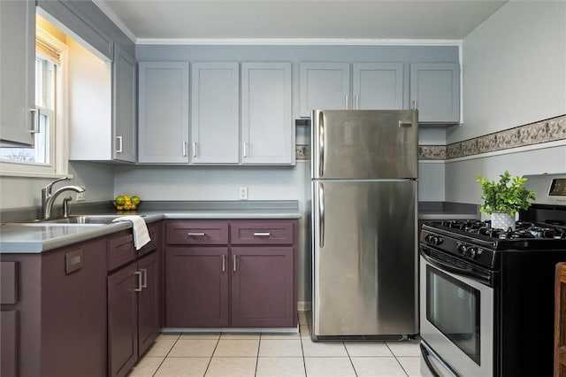 kitchen featuring a sink, ornamental molding, light tile patterned flooring, and stainless steel appliances