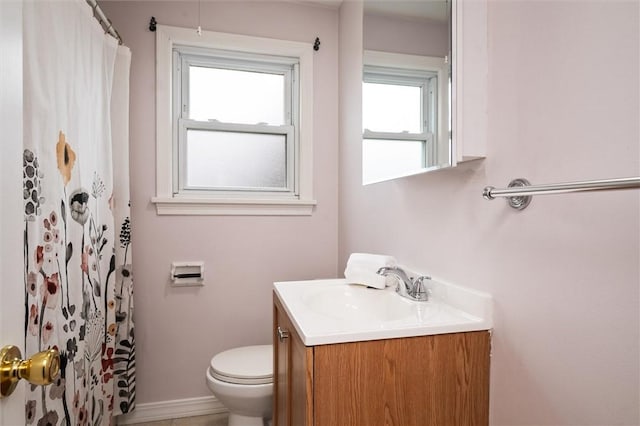 bathroom featuring toilet, vanity, a shower with shower curtain, and baseboards