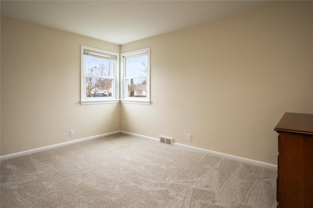 carpeted spare room with baseboards and visible vents