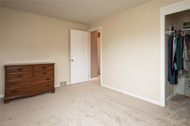 unfurnished bedroom featuring baseboards, visible vents, a spacious closet, a closet, and carpet flooring