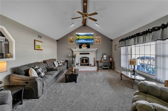 carpeted living area with visible vents, vaulted ceiling with beams, ceiling fan, and a fireplace