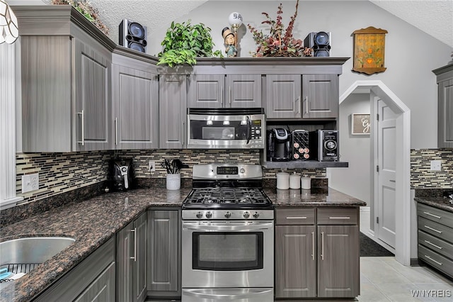 kitchen featuring light tile patterned floors, gray cabinets, and stainless steel appliances