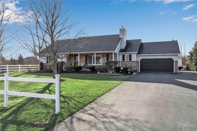 view of front of house featuring fence, a front lawn, a garage, aphalt driveway, and brick siding