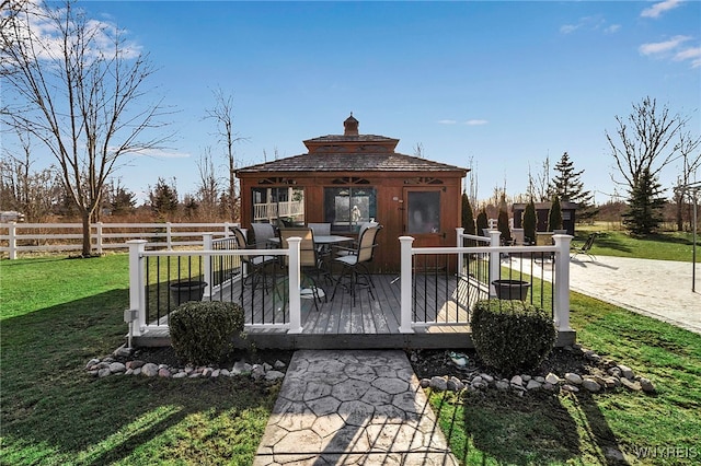 wooden deck with a gazebo, outdoor dining area, fence, and a lawn