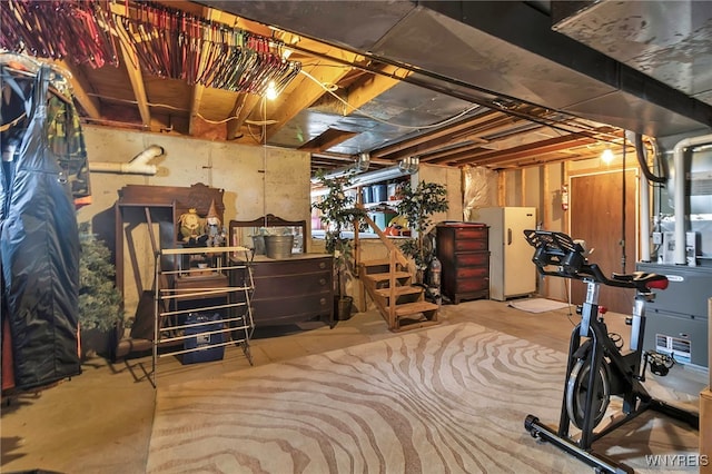 unfinished basement with freestanding refrigerator