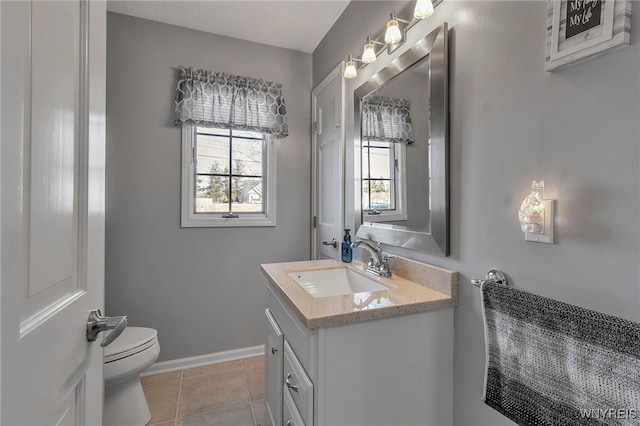 half bathroom featuring vanity, tile patterned floors, toilet, and baseboards