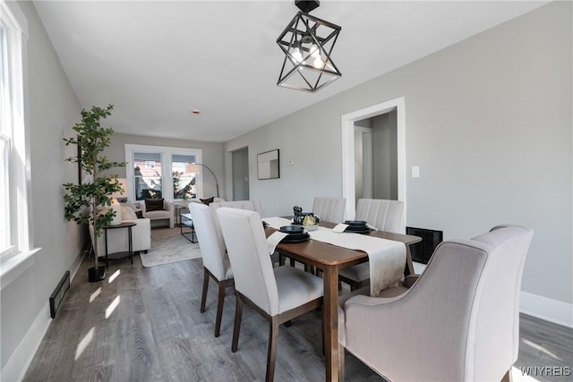 dining area with baseboards and wood finished floors