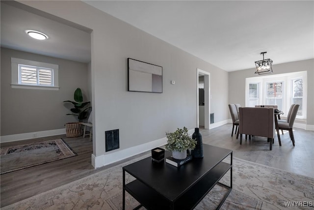 living room featuring visible vents, wood finished floors, and baseboards