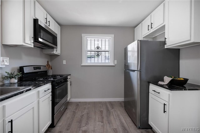 kitchen with dark countertops, dark wood finished floors, stainless steel appliances, and baseboards