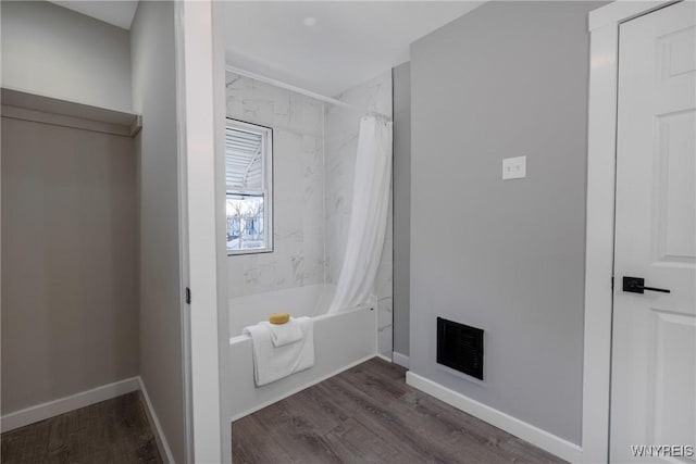 bathroom with visible vents, shower / bathtub combination with curtain, baseboards, and wood finished floors