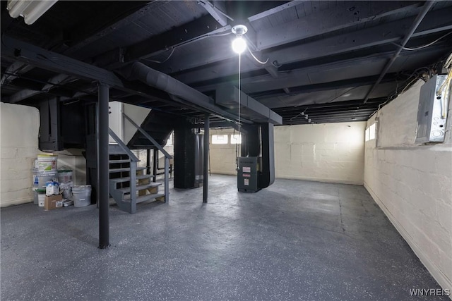 basement with heating unit, stairway, and electric panel