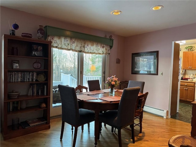 dining area featuring light wood finished floors and baseboard heating