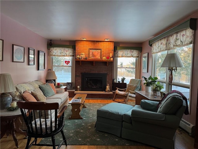 living room with baseboard heating, a fireplace, and wood finished floors