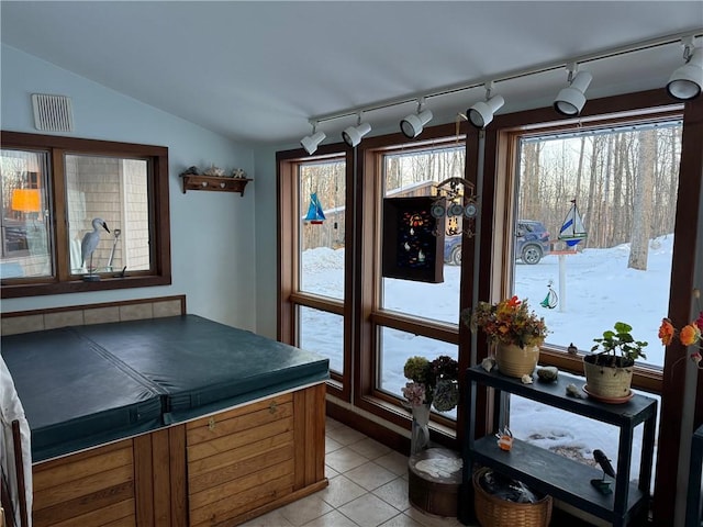 kitchen featuring lofted ceiling, dark countertops, a healthy amount of sunlight, and light tile patterned flooring