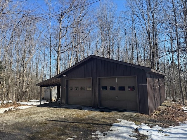 snow covered garage with a detached garage