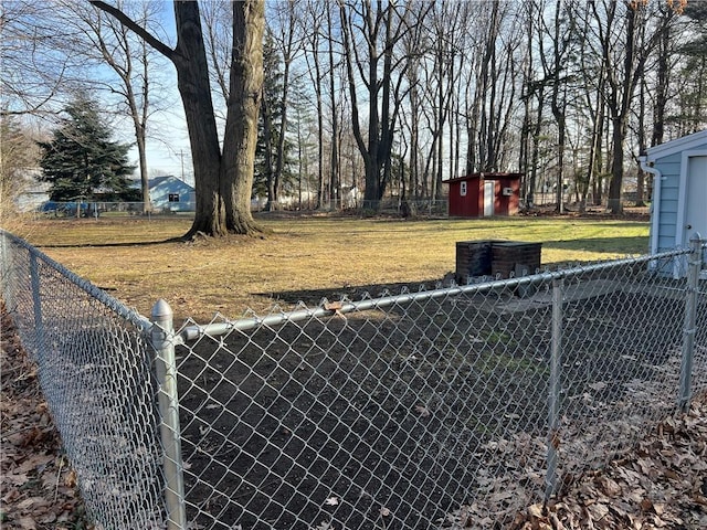 view of yard featuring an outbuilding, a shed, and fence