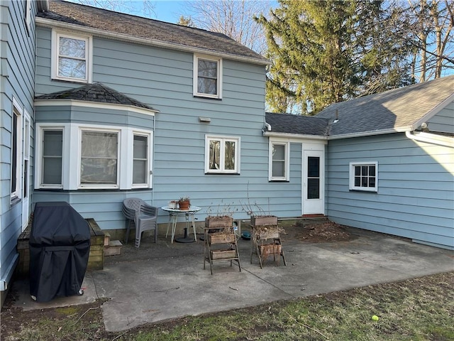 back of property featuring a patio and roof with shingles