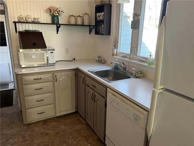 kitchen featuring a sink, open shelves, white appliances, and light countertops